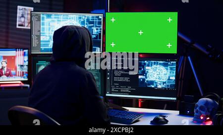 Hacker using AI machine learning and isolated screen computer to produce malware corrupting data. Scammer working on chroma key PC using artificial intelligence tech, infecting systems, camera B Stock Photo