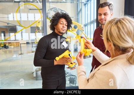 Group of engineers collaborating on robotics development, focusing on training, programming, and gripper arms for industrial applications. Stock Photo