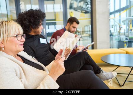Group of professionals sitting and reviewing documents in a modern office environment. Stock Photo