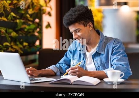 Smart Young Guy Working on Laptop With Cup of Coffee Stock Photo