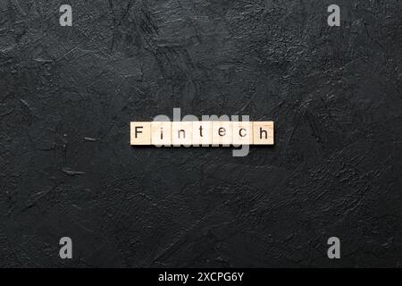 FINTECH word written on wood block. FINTECH text on cement table for your desing, concept. Stock Photo