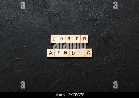 learn arabic word written on wood block. learn arabic text on table, concept. Stock Photo