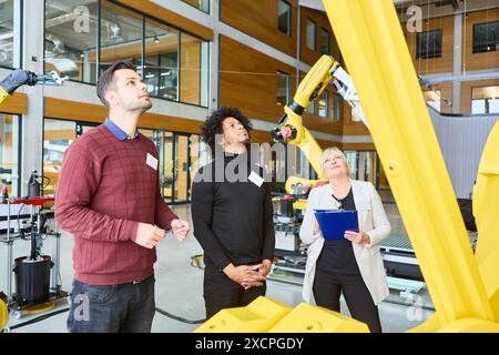 Group of engineers and scientists examining multi-purpose robotic arms for industrial applications. Collaboration in a modern laboratory setting for r Stock Photo