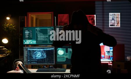 Hackers found by cybercriminal law enforcement escaping with stolen data on SSD after failing to conceal online identity. Criminal in hideout running from police after hacking into servers, camera A Stock Photo