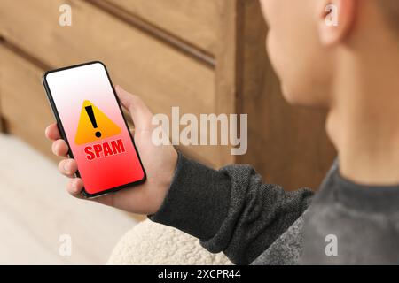 Man using smartphone indoors, closeup. Spam message notification on device screen, illustration Stock Photo