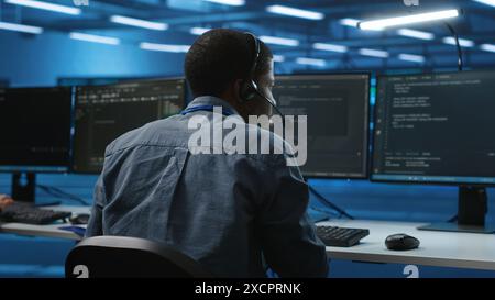 IT support expert in server room talking on headphones with admin about equipment storing datasets. Employee remotely chatting with specialist to mend data center racks doing computational operations Stock Photo
