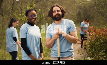 Portrait of diverse activists team tidying natural environment by working on reforestation and engaging in litter cleanup, recycle garbage. Volunteers protecting wildlife and ecosystems. Camera A. Stock Photo