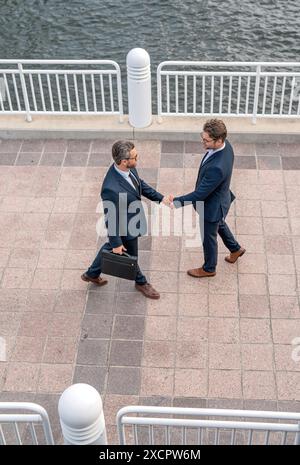 Handshake with partner in the city for greeting. Businessmen in suit shaking hands outdoors. Handshake between two businessmen. wo business men had Stock Photo