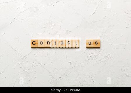 Contact Us word written on wood block. Contact Us text on cement table for your desing, concept. Stock Photo