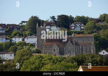 The 11th Century Church of Saint Leonard's, Hythe, Kent, UK. Showing part of Hythe town and the hill rising behind the church. Stock Photo