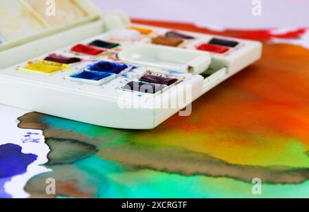 Case with watercolor pills of different colors on abstract background Stock Photo