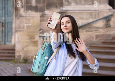Beautiful travel blogger with smartphone streaming outdoors Stock Photo