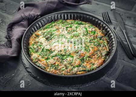 Spinach quiche, omelet or frittata with cheese, eggs and herbs Stock Photo