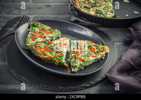 Spinach quiche, omelet or frittata with cheese, eggs and herbs Stock Photo
