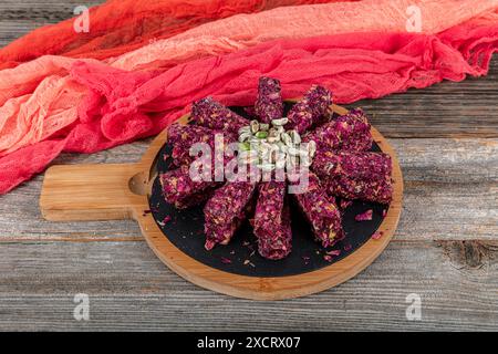 Rosy Turkish Delight with Pistachio and Rose. Sweet roll with roses and nuts, turkish sweets. Rose turkish delight local name; fistikli gullu fitil lo Stock Photo