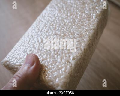 Male hands holds. package of rice for preparing risotto. Vacuum packed to preserve the quality of rice grains. A modern way to store cereals. Rectangu Stock Photo