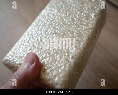 Male hands holds. package of rice for preparing risotto. Vacuum packed to preserve the quality of rice grains. A modern way to store cereals. Rectangu Stock Photo