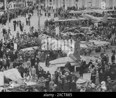 This photograph captures a moment of triumph at Gorky Central Park of Culture and Rest in Moscow, following the successful repulsion of Nazi forces. Citizens are seen gathering around captured Nazi warplanes, displayed as trophies of victory. These aircraft, symbols of the enemy's might, now serve as testament to the resilience and bravery of the defenders. Stock Photo