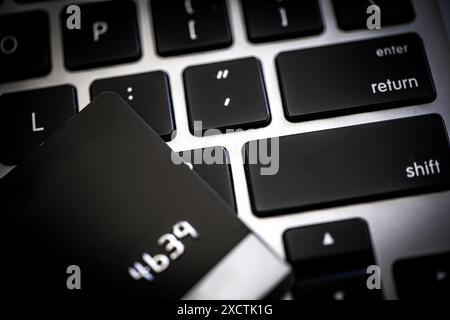 A close-up capturing black credit card placed on a laptop keyboard, emphasizing modern financial technologies and secure electronic transaction, virus Stock Photo