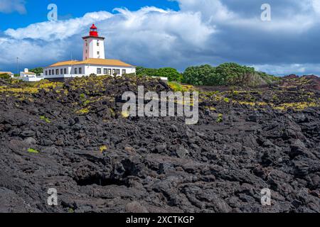 Lighthouse on the tip of the island surrounded by young solidified lava in Pico-Manhenha-Açores. Stock Photo