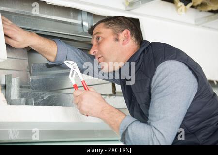 male checking the state of a window frame Stock Photo