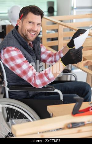 disabled worker in wheelchair in a carpenters workshop Stock Photo