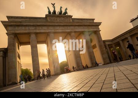 Berlin, Germany – MAY 4 2023: Tourists and people visiting The Brandenburg Gate at sunset as the sun sets behind it in Pariser Platz, Berlin, Germany Stock Photo