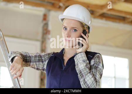woman builder with blueprints using smart phone Stock Photo
