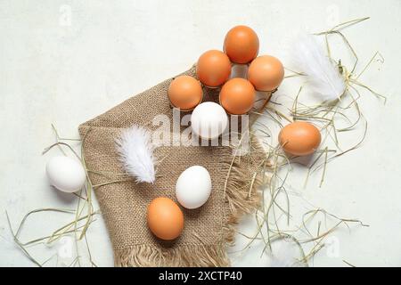 Holder with raw chicken eggs and sack cloth on white background Stock Photo