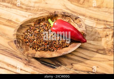 Chilli peppers and crushed chilli peppers on a wooden board Stock Photo