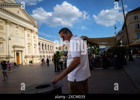 Warsaw, Poland. 17th June, 2024. A man puts out a cigarette on a trash receptacle in Warsaw, Poland on 17 June, 2024. (Photo by Jaap Arriens/Sipa USA) Credit: Sipa USA/Alamy Live News Stock Photo