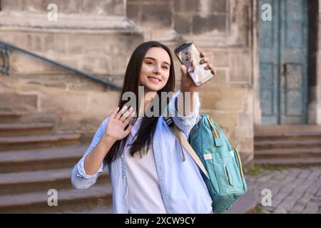Beautiful travel blogger with smartphone streaming outdoors Stock Photo
