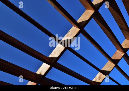 Geometrical shape made of brown wooden board on a dark blue sky. Stock Photo