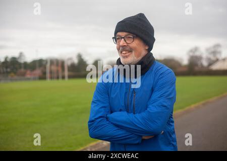 An elderly man goes in for sports, runs in the fresh air in sportswear Stock Photo