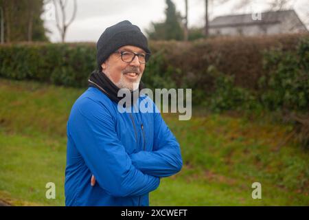 An elderly man goes in for sports, runs in the fresh air in sportswear Stock Photo