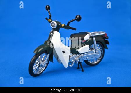 Honda Super Cub toy on blue background – Wales, UK  – 15 June 2024 Stock Photo