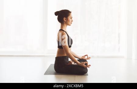 Woman Practicing Yoga in a Seated Meditation Pose Stock Photo