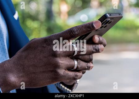 Closeup of African American businessman hands sending message with smartphone. Modern business, technology and communication concept Stock Photo
