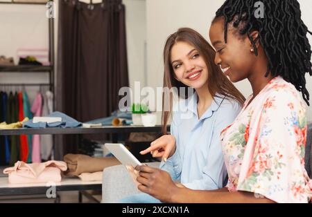 Two Women Looking at Something on a Tablet Stock Photo