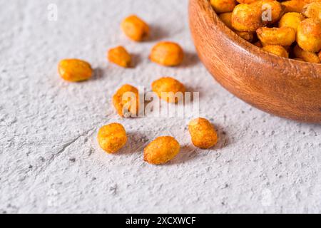 Roasted corn nuts with sauce in wooden bowl on white stone table Stock Photo