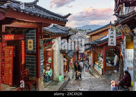 Lijiang, Yunnan Province, China - October 23, 2015: Awesome view of cozy narrow street of the Old Town of Lijiang at sunset. Stock Photo