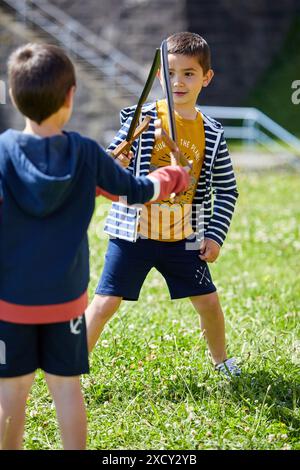 Two boys playing with toy swords, Getaria, Gipuzkoa, Basque Country, Spain Stock Photo