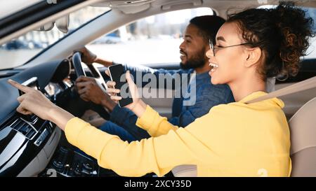 Woman Using Navigation App While Passenger Drives Car During Daytime Stock Photo