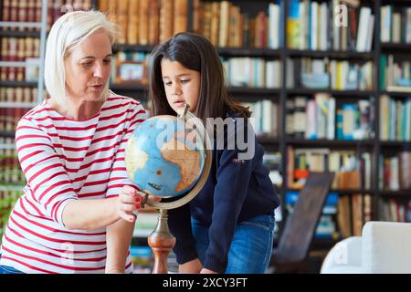 Grandmother and granddaughter, Looking globe of the world, Getaria, Gipuzkoa, Basque Country, Spain, Europe Stock Photo