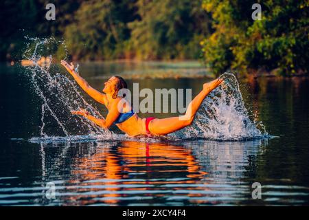 Young woman splashing in lake Stock Photo