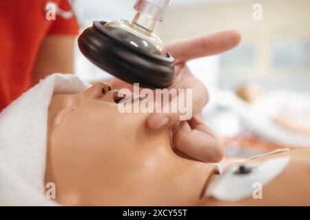 Hands of paramedic of emergency medical service during training resuscitation training on newborn dummy. Stock Photo