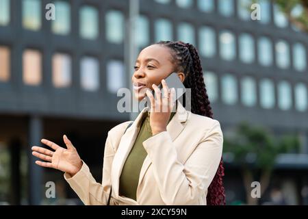 Confident Black Woman Entrepreneur Talking On Phone Outdoors Stock Photo