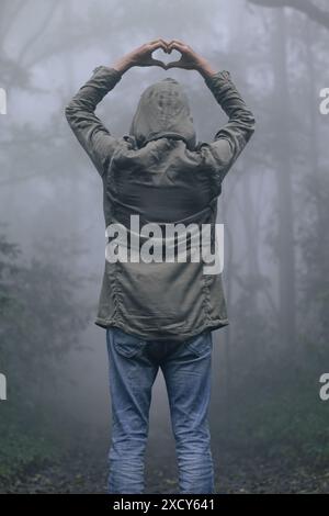 A young man uses sign language to express his love and friendship to his friend and lover. Sign language concept shows heart symbol to express love, f Stock Photo