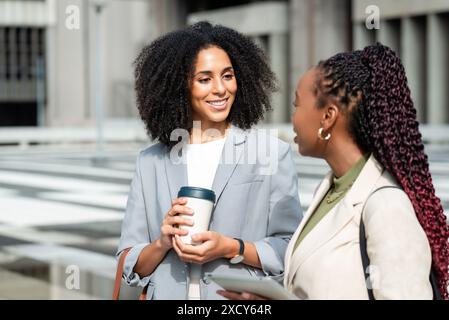 Two Black Businesswomen Engaging in a Professional Conversation Outdoors Stock Photo