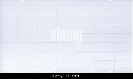 Front view of a plastered and painted white stone or concrete wall with rectangle blocks or tiles. Abstract full frame textured background, copy space Stock Photo
